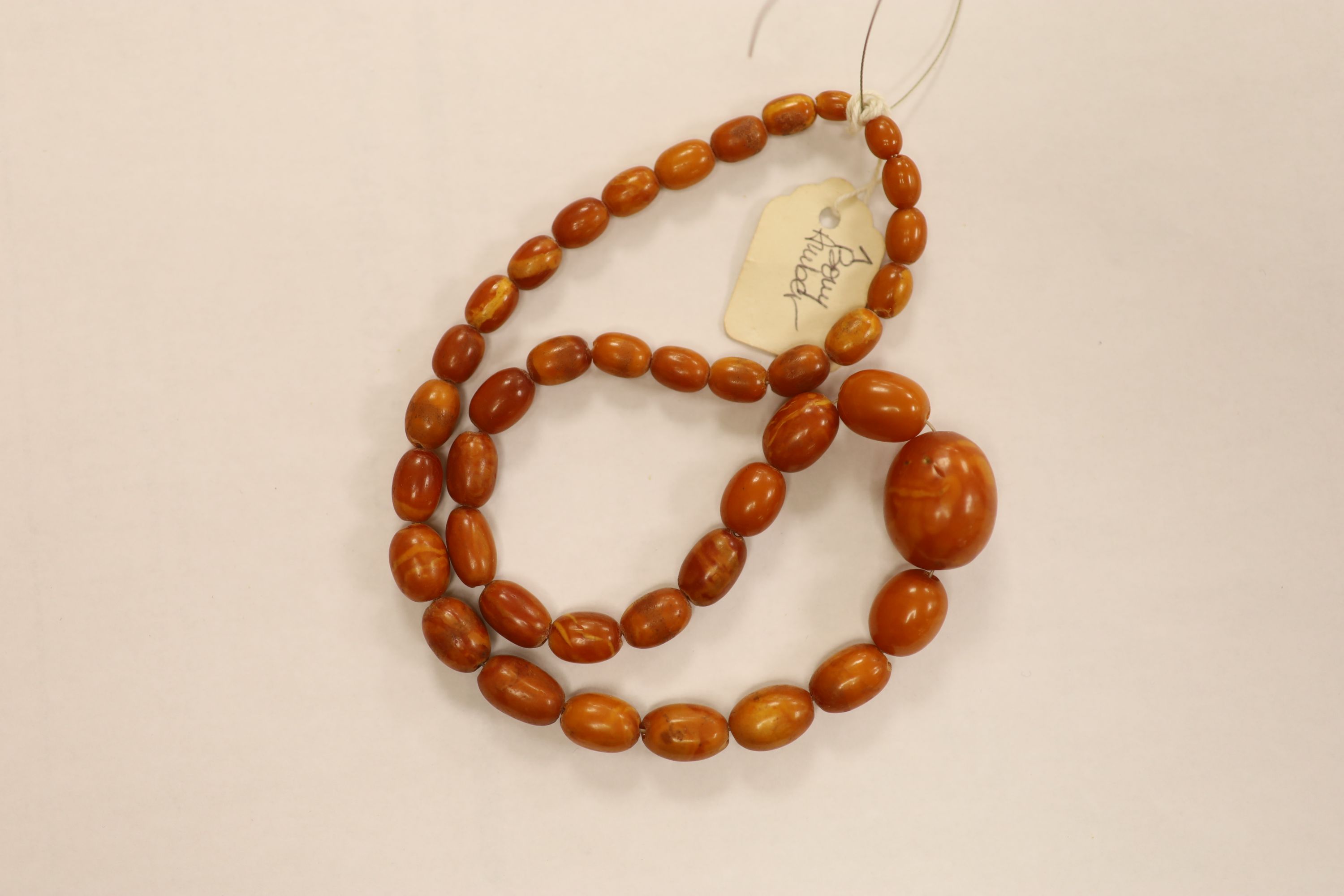 Nine assorted single strand amber bead necklaces, longest approximately 46cm, gross weight 173 grams and one simulated amber bead necklace.